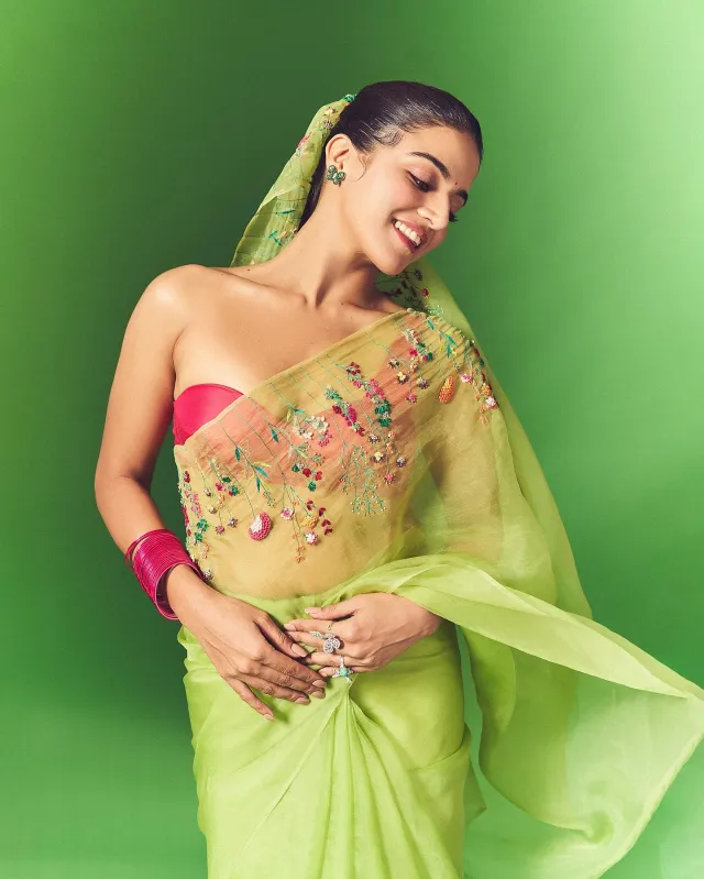 ওয়ামিকা একটি লাইম গ্রিন অরগাঞ্জা শাড়িতে সেজেছেন, যার সাথে রয়েছে ওয়ান শোল্ডার হট পিঙ্ক স্ট্র্যাপলেস ব্লাউজ।