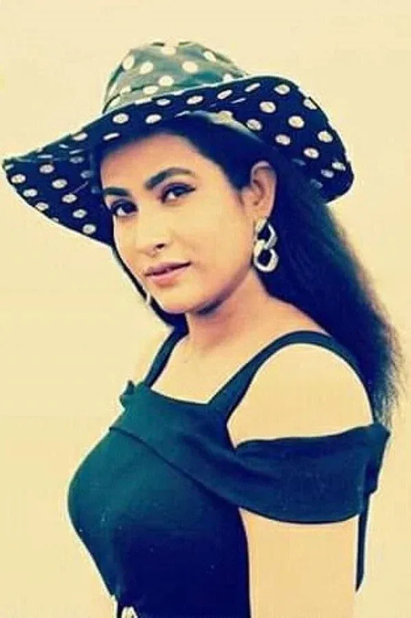 চম্পা পোলকা ডটের টুপি এবং কালো স্লিভলেস টপের সাথে অফ-শোল্ডার স্টাইলে আধুনিক দুল পরেছেন।