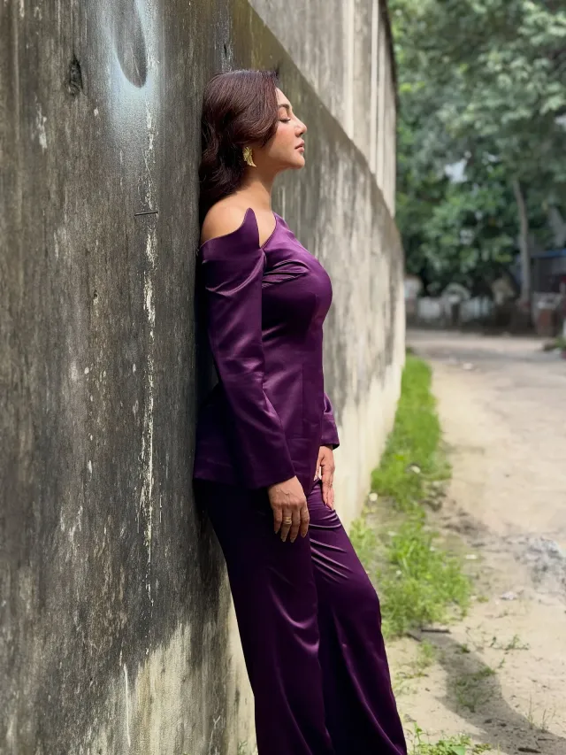 চুল একপাশে সিঁথি করে সফট কার্লে ছেড়ে রেখেছেন, যা কাঁধের নকশা ফুটিয়ে তুলেছে।