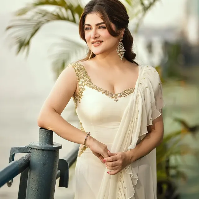 পোশাক জুড়ে সোনালি সিকুইনের ঝলক ও প্লিটেড নিচের অংশ।
