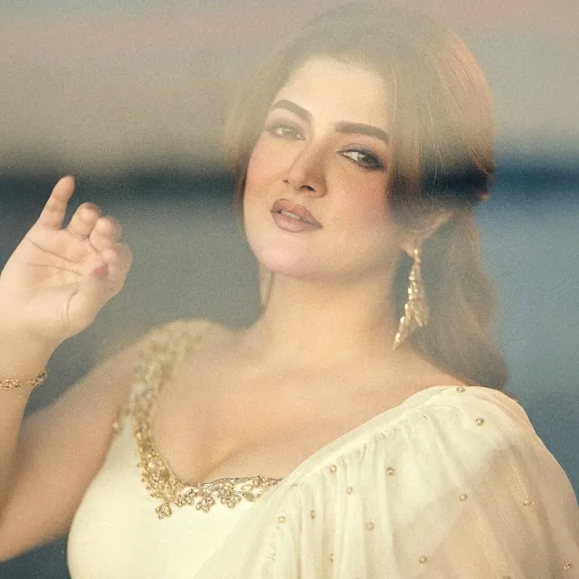 মাঝখান থেকে সিঁথি করা চুল হাফ আপডু স্টাইলে বাঁধা।