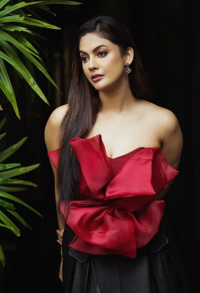 স্ট্র্যাপলেস ড্রেসের বডিতে বড় লাল বো ও কালো স্কার্টে সৈরিতী, কানে হার্ট শেপ দুল।